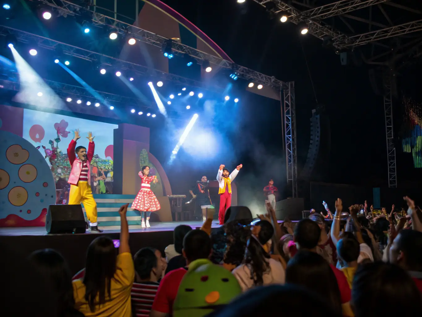 A vibrant photograph capturing a live performance organized by ASSOCIATION EMILE BOREL, showcasing musicians and dancers on stage with an enthusiastic audience.